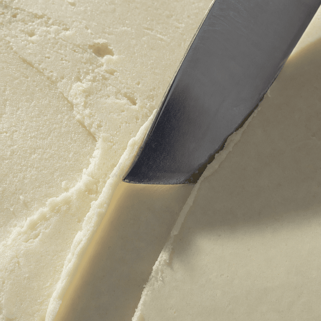 Close-up of solid mango butter with a spatula furrow